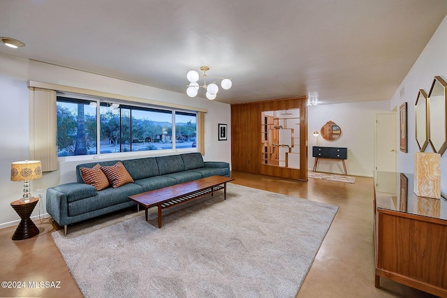 living room featuring an inviting chandelier, wooden walls, and concrete floors