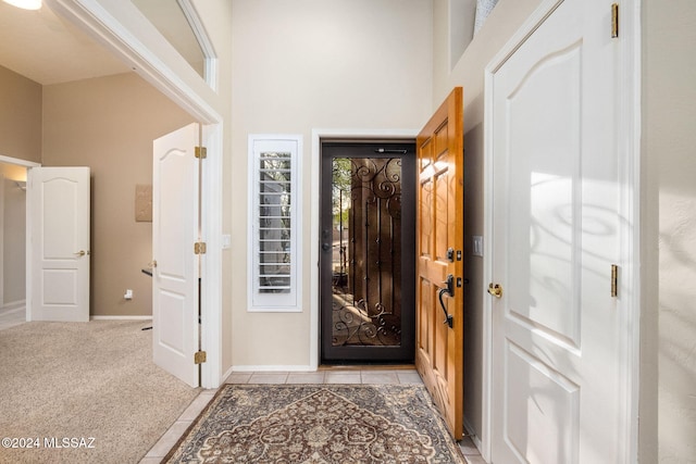 carpeted foyer featuring a high ceiling