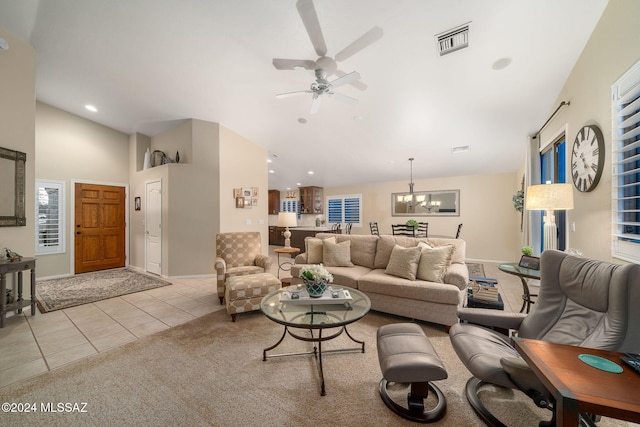 tiled living room with ceiling fan with notable chandelier