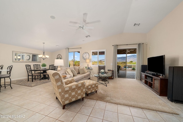 living room with ceiling fan with notable chandelier, light tile patterned floors, and lofted ceiling