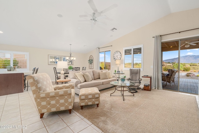 tiled living room featuring vaulted ceiling, ceiling fan with notable chandelier, and a mountain view