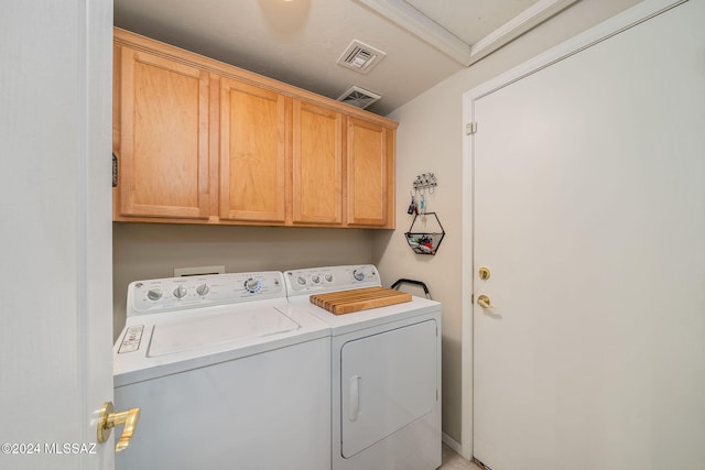 washroom with washer and dryer and cabinets