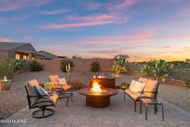 patio terrace at dusk featuring an outdoor fire pit