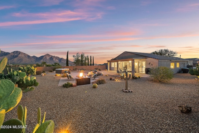 exterior space featuring a mountain view, an outdoor fire pit, and a patio