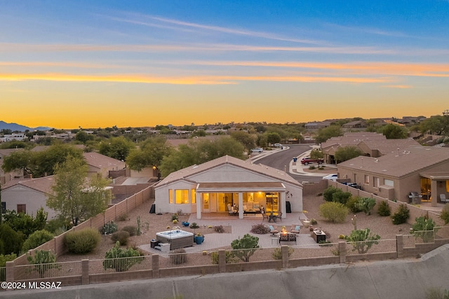 back house at dusk featuring an outdoor fire pit and a patio