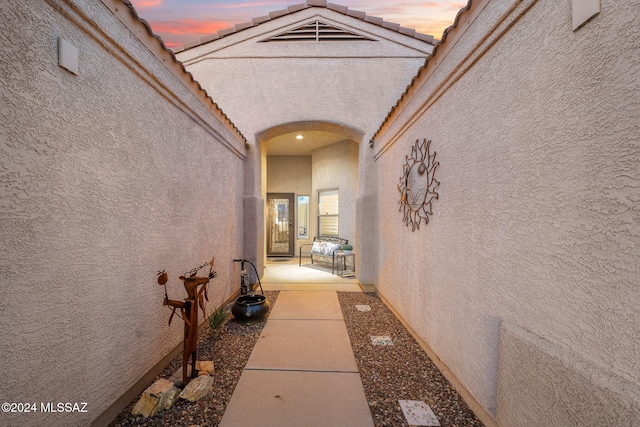 exterior entry at dusk featuring a patio