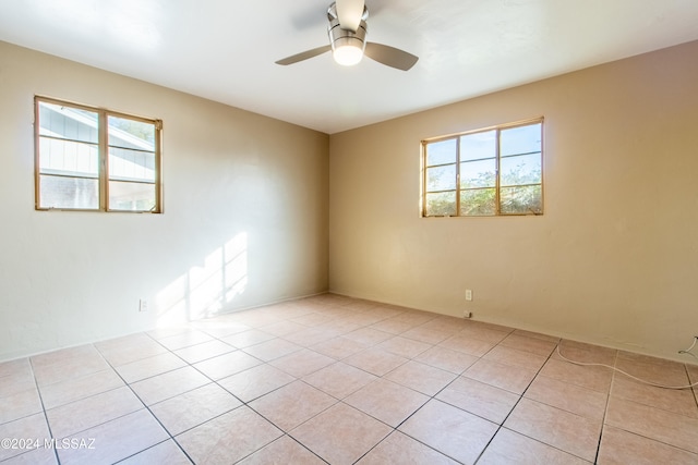 tiled empty room with plenty of natural light and ceiling fan