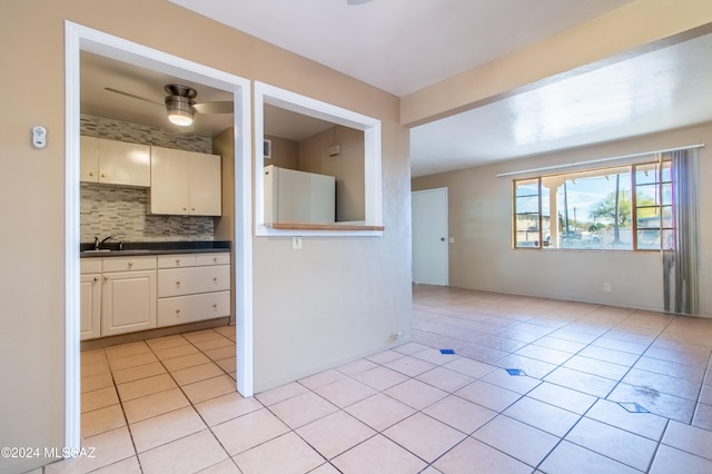 kitchen with backsplash, sink, light tile patterned flooring, and white refrigerator