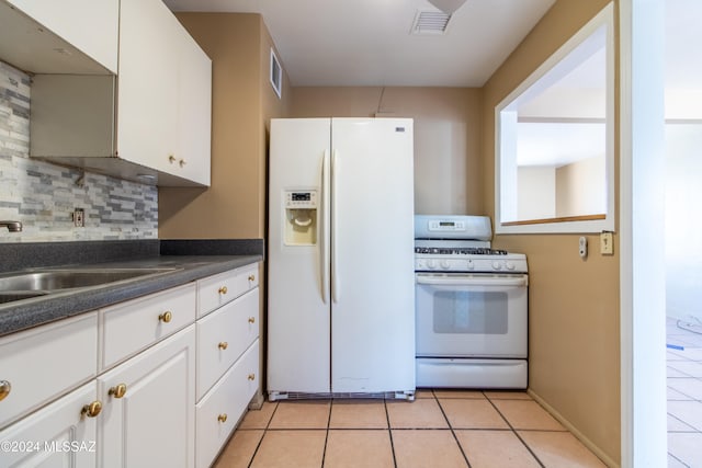 kitchen featuring white appliances, white cabinets, sink, decorative backsplash, and light tile patterned floors