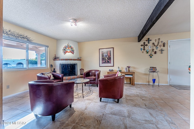 living room with a fireplace, beamed ceiling, and a textured ceiling