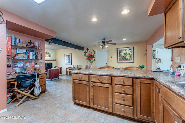 kitchen featuring kitchen peninsula, ceiling fan, and light tile patterned floors