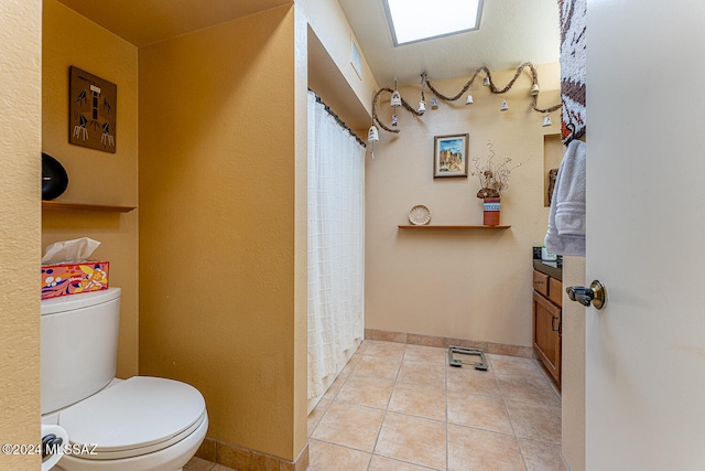 bathroom featuring tile patterned flooring, vanity, and toilet