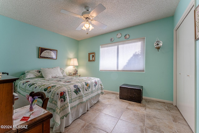 tiled bedroom with a textured ceiling, a closet, and ceiling fan