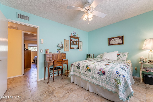 tiled bedroom with a textured ceiling and ceiling fan