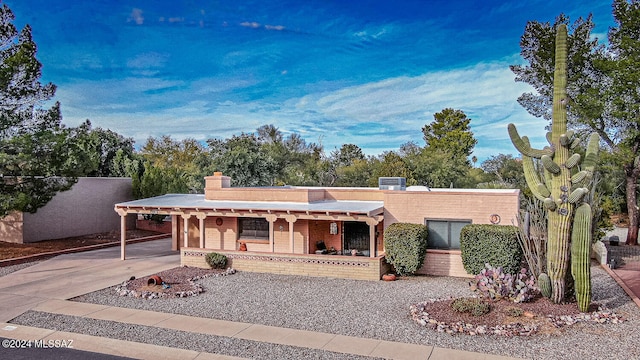 view of front of property featuring a carport, a porch, and central AC unit