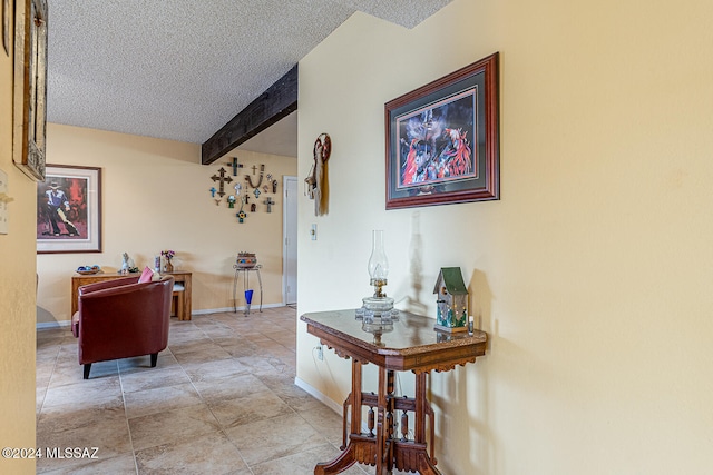 hallway with beamed ceiling and a textured ceiling