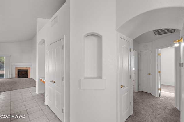 hall with light colored carpet and lofted ceiling