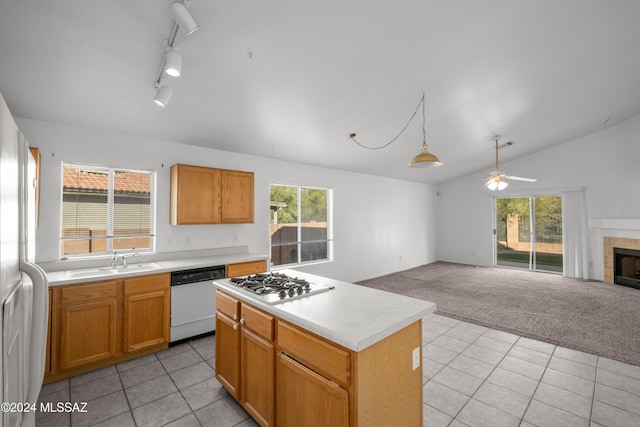 kitchen featuring lofted ceiling, white appliances, sink, a kitchen island, and light colored carpet