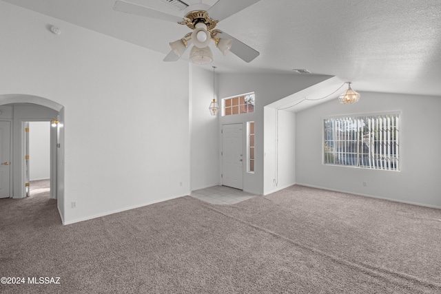 unfurnished living room featuring a wealth of natural light, light carpet, and lofted ceiling