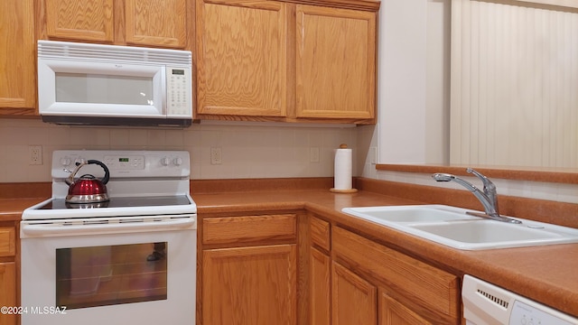 kitchen with decorative backsplash, white appliances, and sink