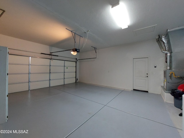 garage featuring a garage door opener and heating unit