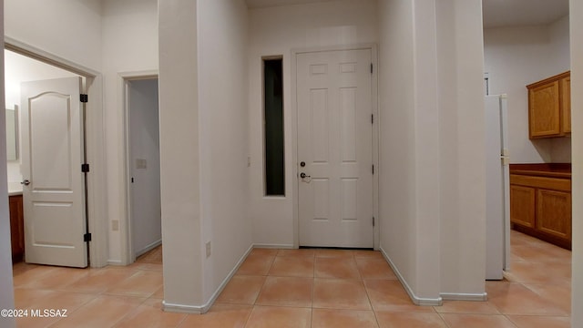 hall featuring light tile patterned floors