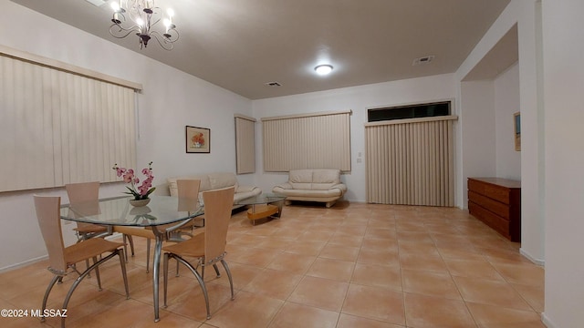 tiled dining space featuring an inviting chandelier