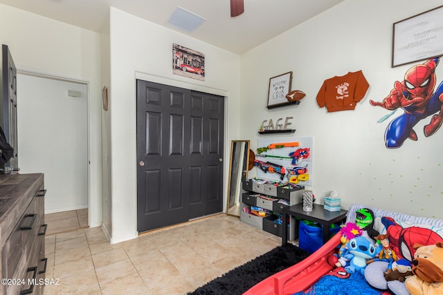 bedroom featuring light tile patterned flooring, a closet, and ceiling fan