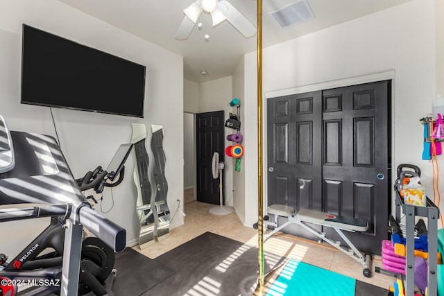 exercise area featuring ceiling fan and tile patterned flooring