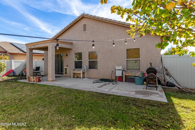 back of house featuring a lawn and a patio