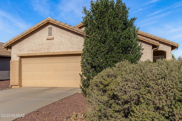 21330 E Reunion Rd, Red Rock, AZ 85145 - view of front facade with a tiled roof, stucco siding, a garage, and concrete driveway