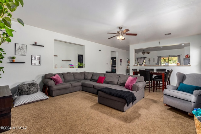 carpeted living room with ceiling fan