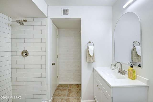 bathroom with vanity and tiled shower