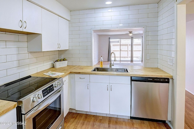 kitchen featuring white cabinetry, sink, stainless steel appliances, and light hardwood / wood-style floors