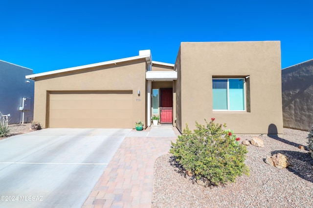 pueblo revival-style home featuring a garage