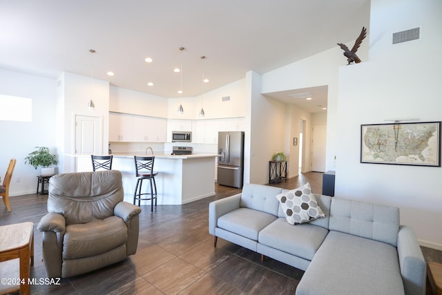 tiled living room featuring sink and high vaulted ceiling