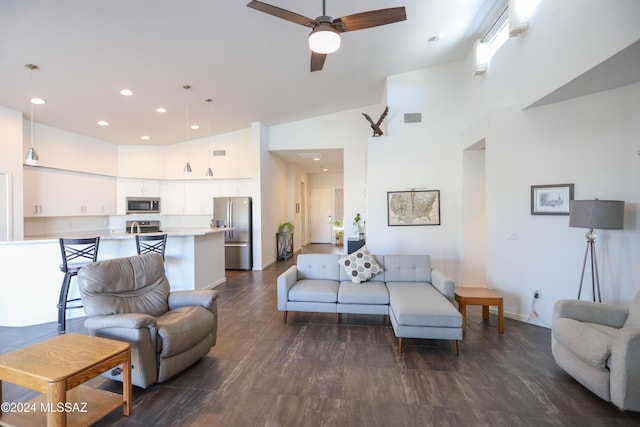 living room featuring dark hardwood / wood-style floors, high vaulted ceiling, and ceiling fan