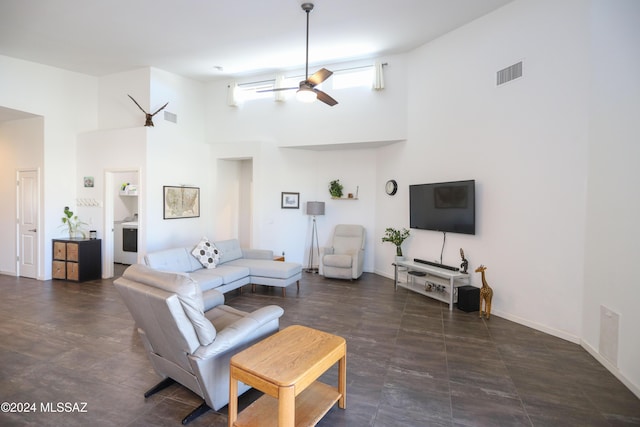 living room with ceiling fan, washer / clothes dryer, and a high ceiling