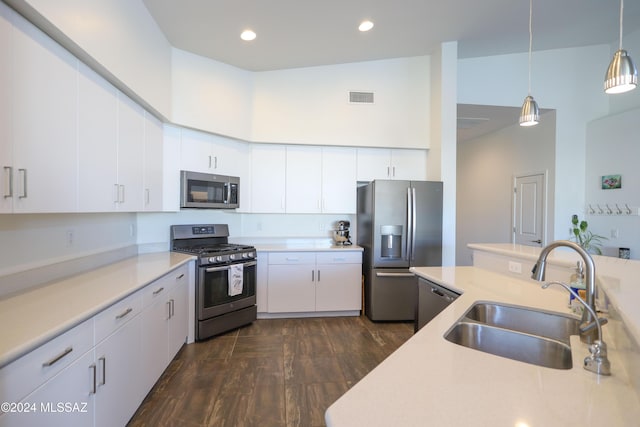 kitchen with white cabinets, appliances with stainless steel finishes, pendant lighting, and sink