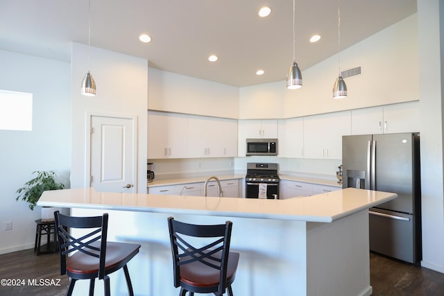 kitchen featuring appliances with stainless steel finishes, dark hardwood / wood-style flooring, white cabinetry, and a large island