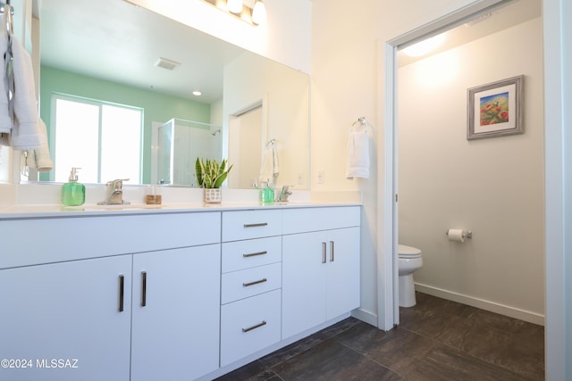 bathroom with vanity, a shower with shower door, and toilet