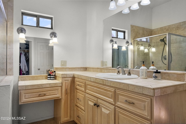 bathroom with a healthy amount of sunlight, an enclosed shower, and vanity