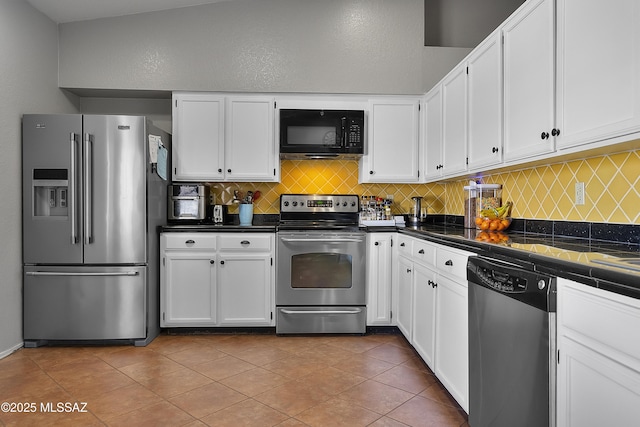 kitchen with backsplash, appliances with stainless steel finishes, light tile patterned floors, and white cabinets