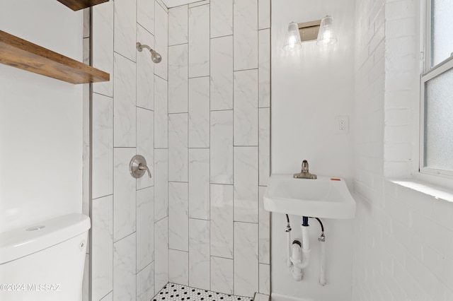 bathroom featuring a tile shower and toilet