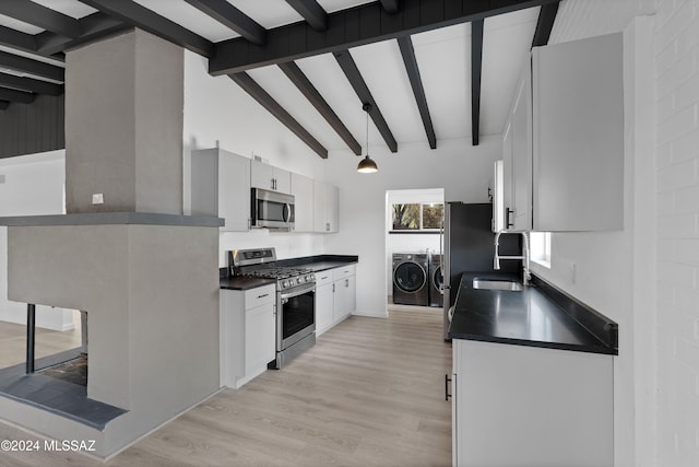 kitchen featuring beam ceiling, white cabinets, washer and dryer, and appliances with stainless steel finishes