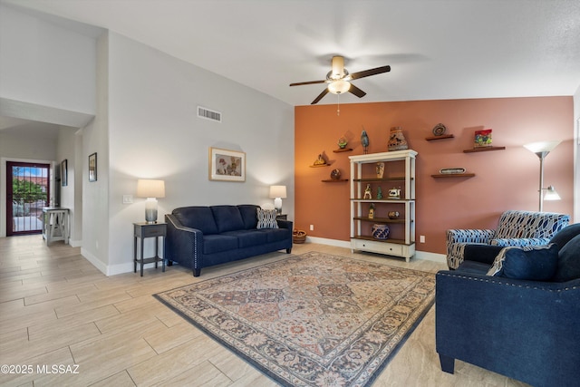 living room with visible vents, ceiling fan, baseboards, and wood finish floors