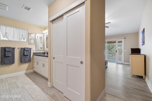 bathroom featuring visible vents, marble finish floor, a ceiling fan, baseboards, and vanity