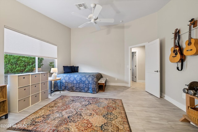 bedroom with visible vents, baseboards, and wood finished floors