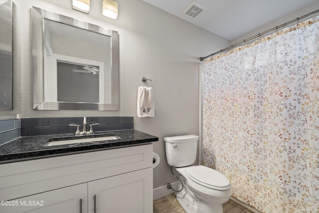 bathroom with vanity, curtained shower, toilet, and visible vents