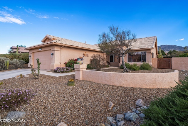 view of front of home with stucco siding, a garage, concrete driveway, and a tiled roof